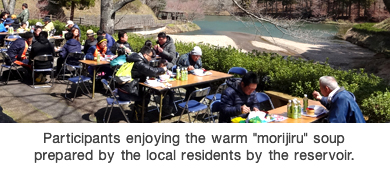 Participants enjoying the warm "morijiru" soup prepared by the local residents by the reservoir.