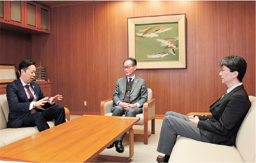 応接室のような場所で、山口商工会議所会頭の河野康志氏と山口大学国際総合科学部長の杉井学氏、西日本電信電話株式会社山口支店長の西一仁が意見を交わしている様子の写真