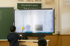 電子黒板に表示されたデジタル教科書にタッチペンで線を引く（佐分利小学校2年生国語）