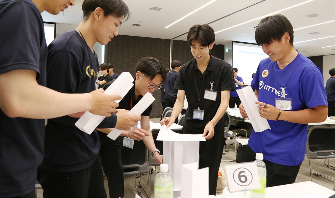 ペーパータワーを組み立てる選手たち