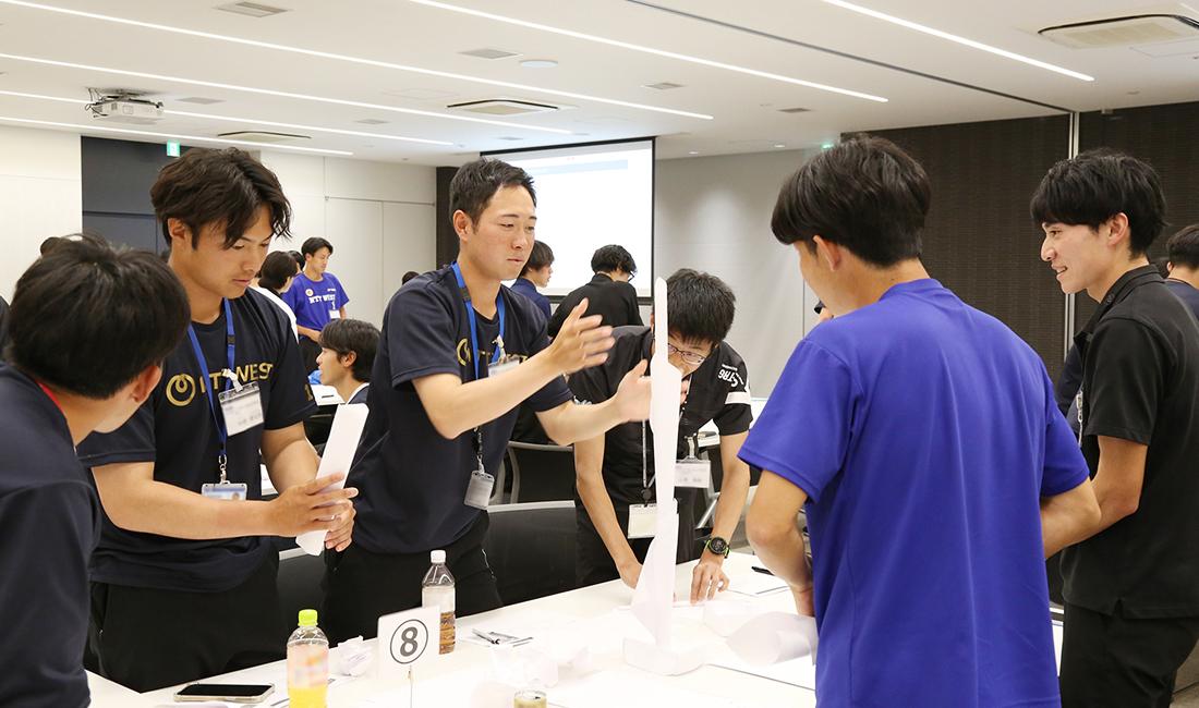 完成したペーパータワーを囲む選手たち